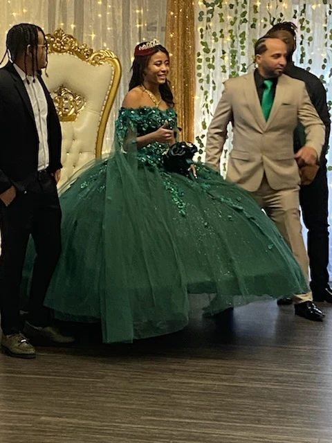 Quinceañera dancing in emerald green ball gown