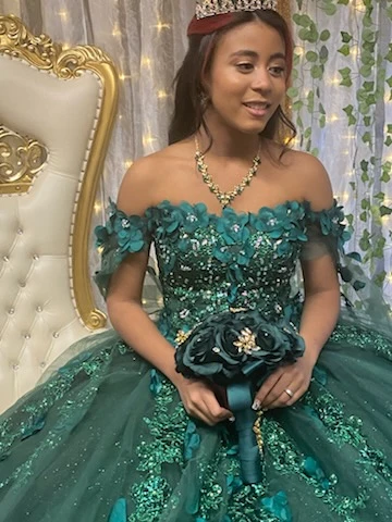 Quinceañera princess in emerald green gown with bouquet closeup