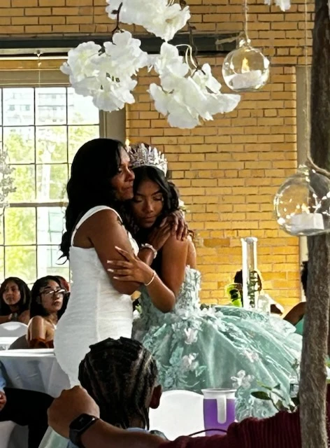 Heartfelt quinceañera moment with embrace in mint green gown