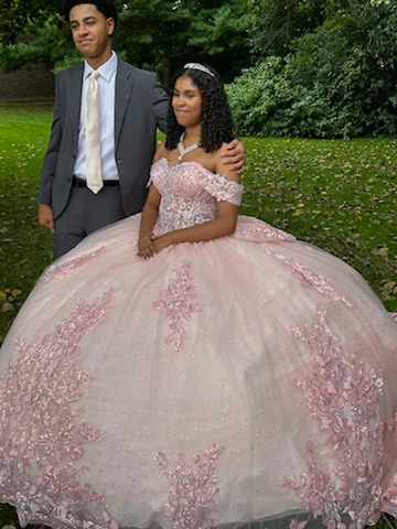 Quinceañera in pink ball gown with chambelan close portrait