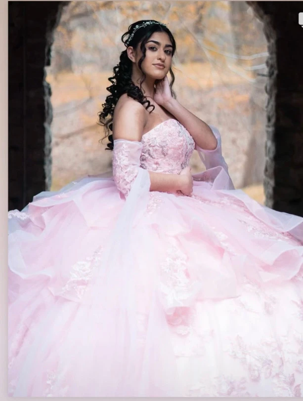 Quinceañera portrait in pink ball gown with autumn backdrop