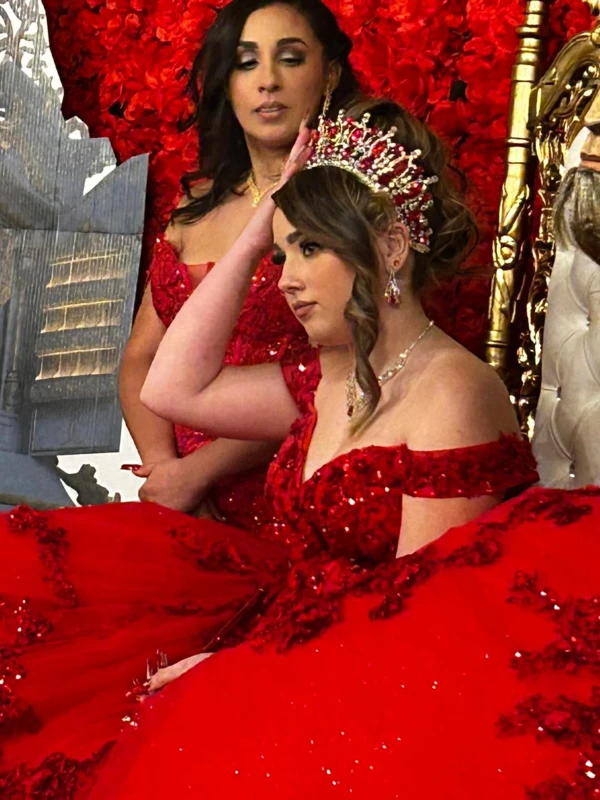 Quinceañera crowning ceremony in red ball gown with rose crown