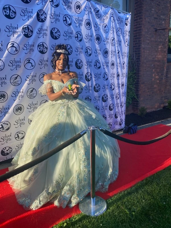 Quinceañera in sage green ball gown on the red carpet